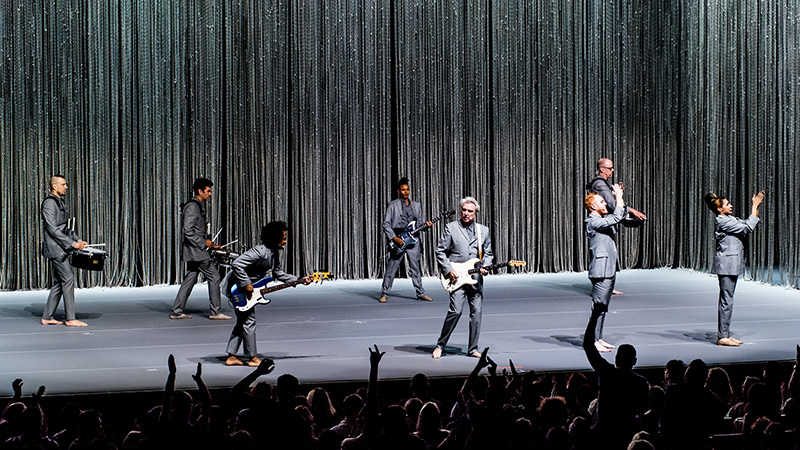 Photo of David Byrne and his band performing on stage